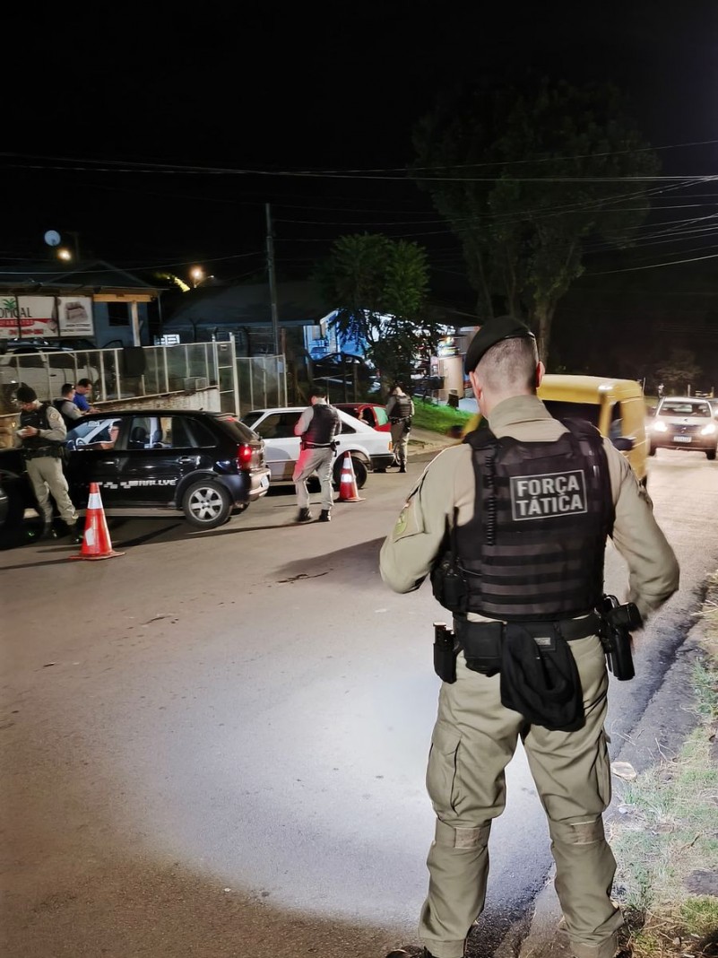 Na foto contém policiais abordando veículos em via pública