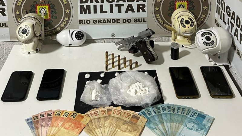 Na foto contém uma pistola, dinheiro, celulares, câmeras de monitoramento e droga
