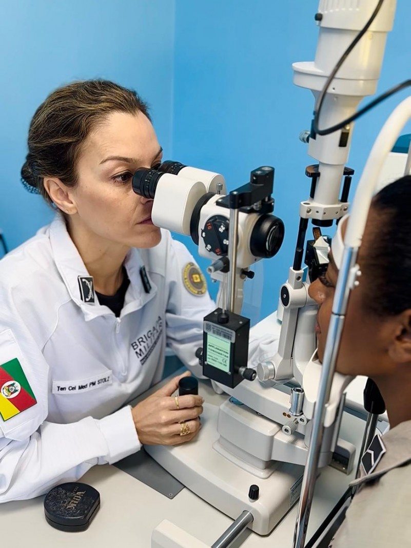 Foto mostra uma médica oftalmologista tenente-coronel da Brigada Militar atendendo uma paciente.
