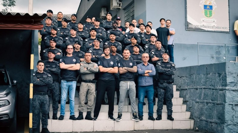Efetivo do 1º BPChq reunido em uma escada , junto aos visitantes.