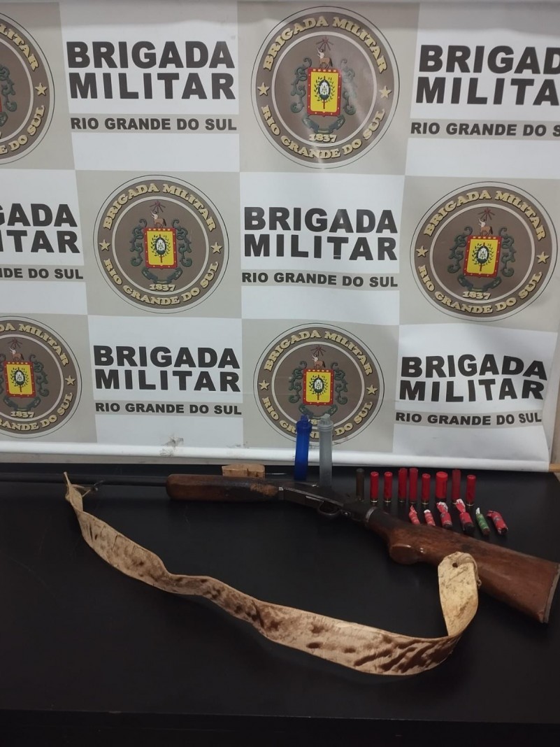 Na foto contém uma espingarda e munições