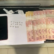 Celular ao lado de drogas e dinheiro 