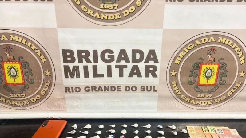 Banner da BM junto de drogas, dinheiro e um celular