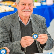 senhor, sorridente, segurando a moeda comemorativa da esfas