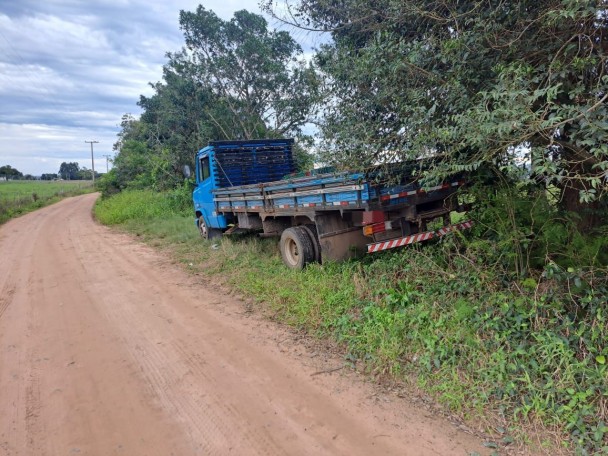Caminhão mercedes cor azul em uma estrada de chão batido