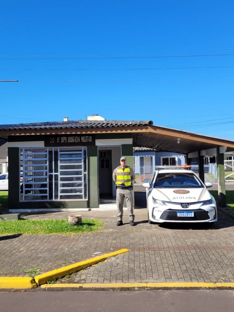 Policial militar realizando posto base ao lado de uma viatura em frente ao módulo da Brigada Militar de Osório