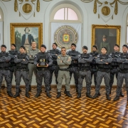 Foto mostra os policiais militares perfilados em uma foto no Salão Nobre do Quartel do Comando-Geral da BM, junto ao Comandante-Geral e Subcomandante-Geral.