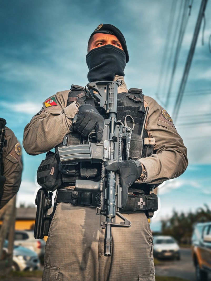 policial militar segurando um fuzil
