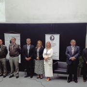 Autoridades militares e civis em fileira no palco portando a Comenda