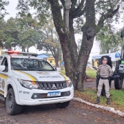 Na imagem policial militar no interior do parque da Fenarroz posicionado ao lado da viatura e das máquinas agrícolas expostas na feira