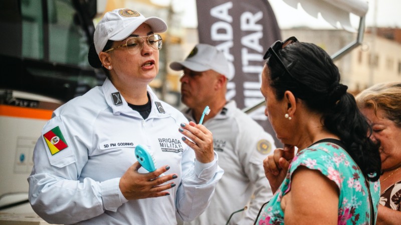 PM feminina servidora do Hospital da Brigada Militar orienta uma cidad&atilde; sobre a escova&ccedil;&atilde;o dent&aacute;ria