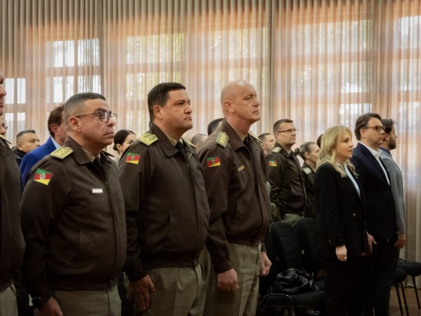 Imagem mostra o Comandante-Geral, o Subcomandante-Geral e o Comandante do CRPM Fronteira Noroeste perfilados no auditório durante o evento