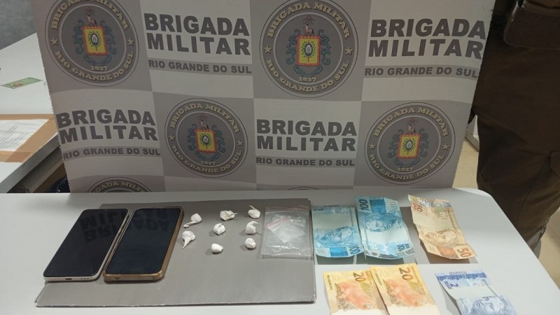 Materiais apreendidos, oito por&ccedil;&otilde;es de coca&iacute;na, totalizando 7,9 gramas, dois aparelhos celulares e R$ 292,00 em moeda corrente.
