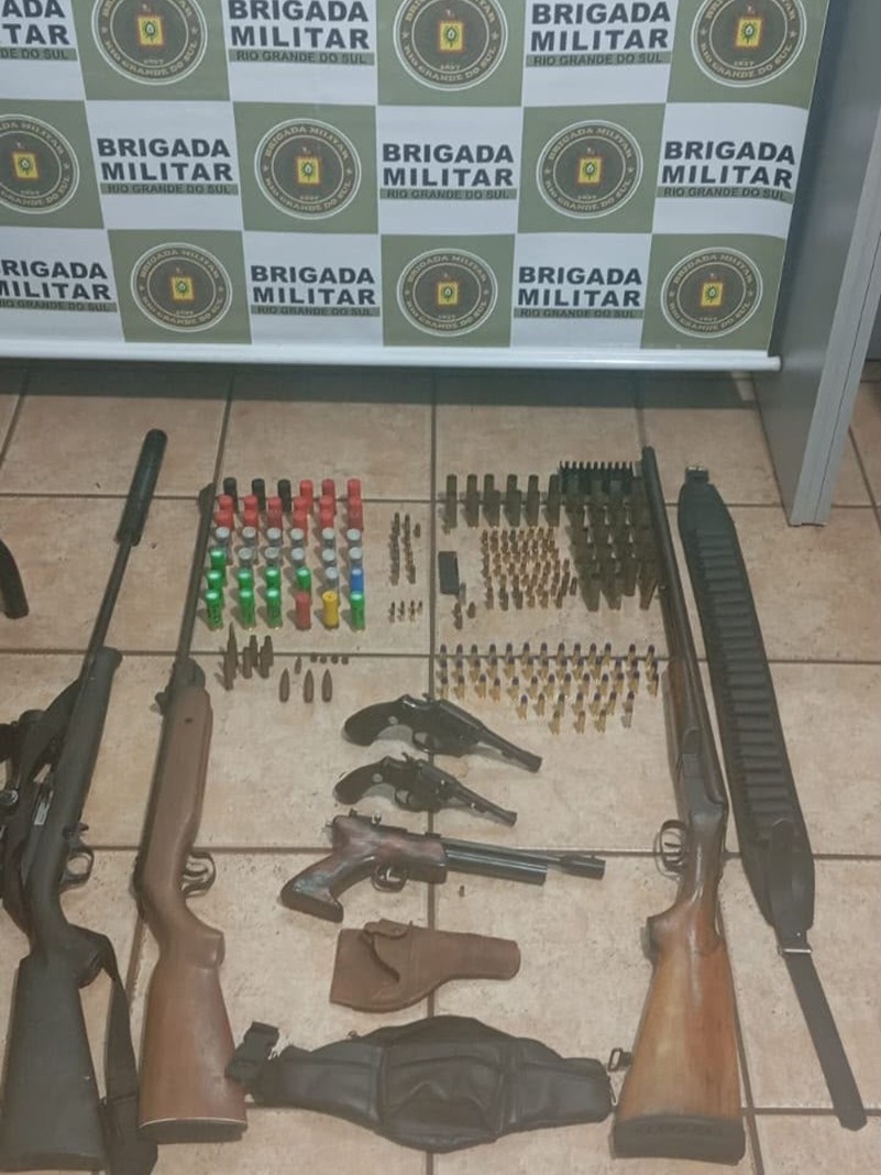Apreens&otilde;es realizadas: muitas armas de fogo de cano longo dispostas, junto a muni&ccedil;&otilde;es, no ch&atilde;o.