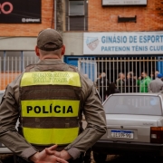 Foto mostra policial militar de costas em frente a um local de vota&ccedil;&atilde;o em Porto Alegre, o Partenon T&ecirc;nis Clube.